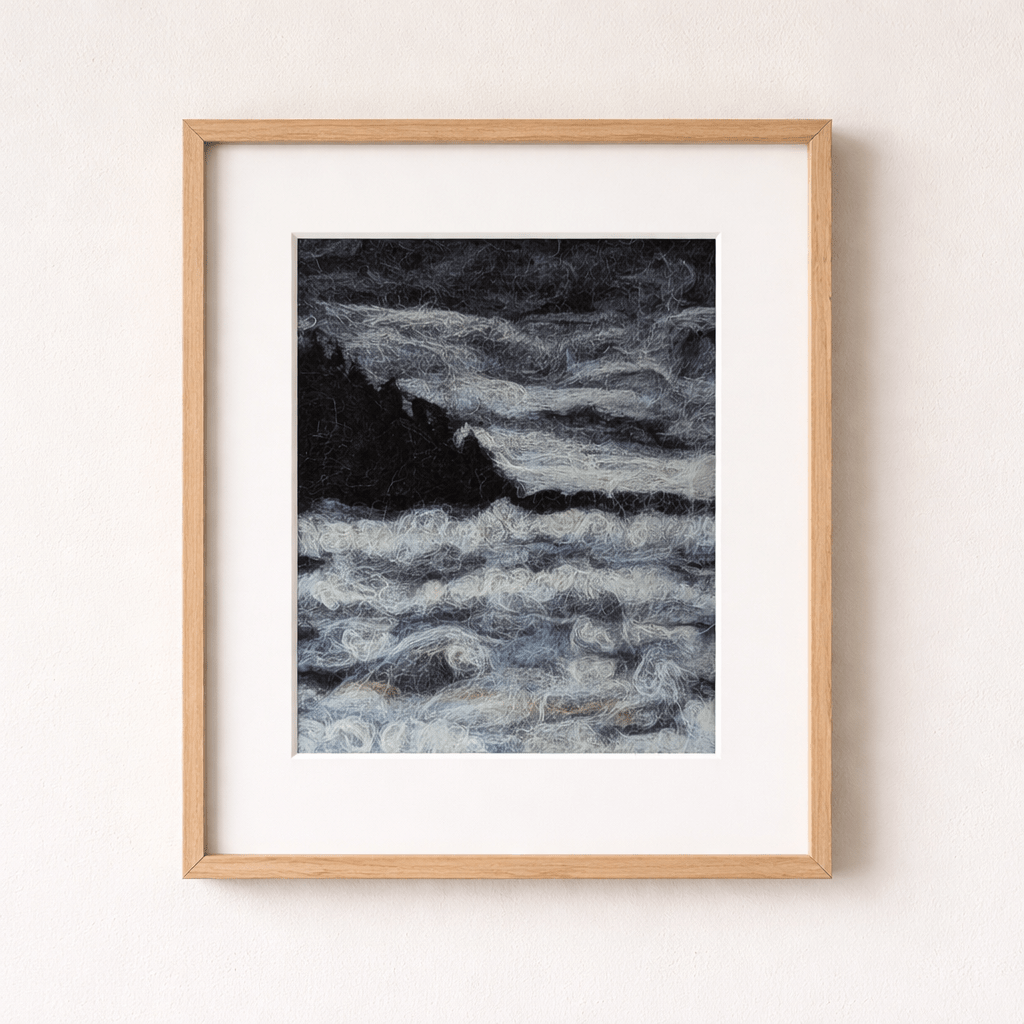 Needle-felted stormy ocean art print showing dark waves and rocky coastline in a natural wood frame.